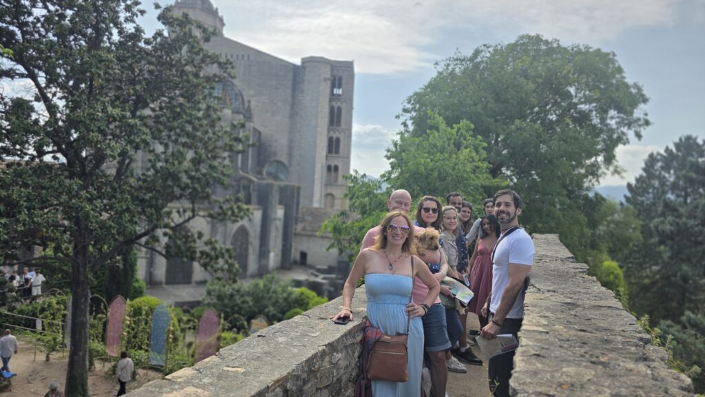 International group enjoying Girona’s Temps de Flors 2025 flower festival, colorful floral decorations in historic city streets – New in Barcelona day trip